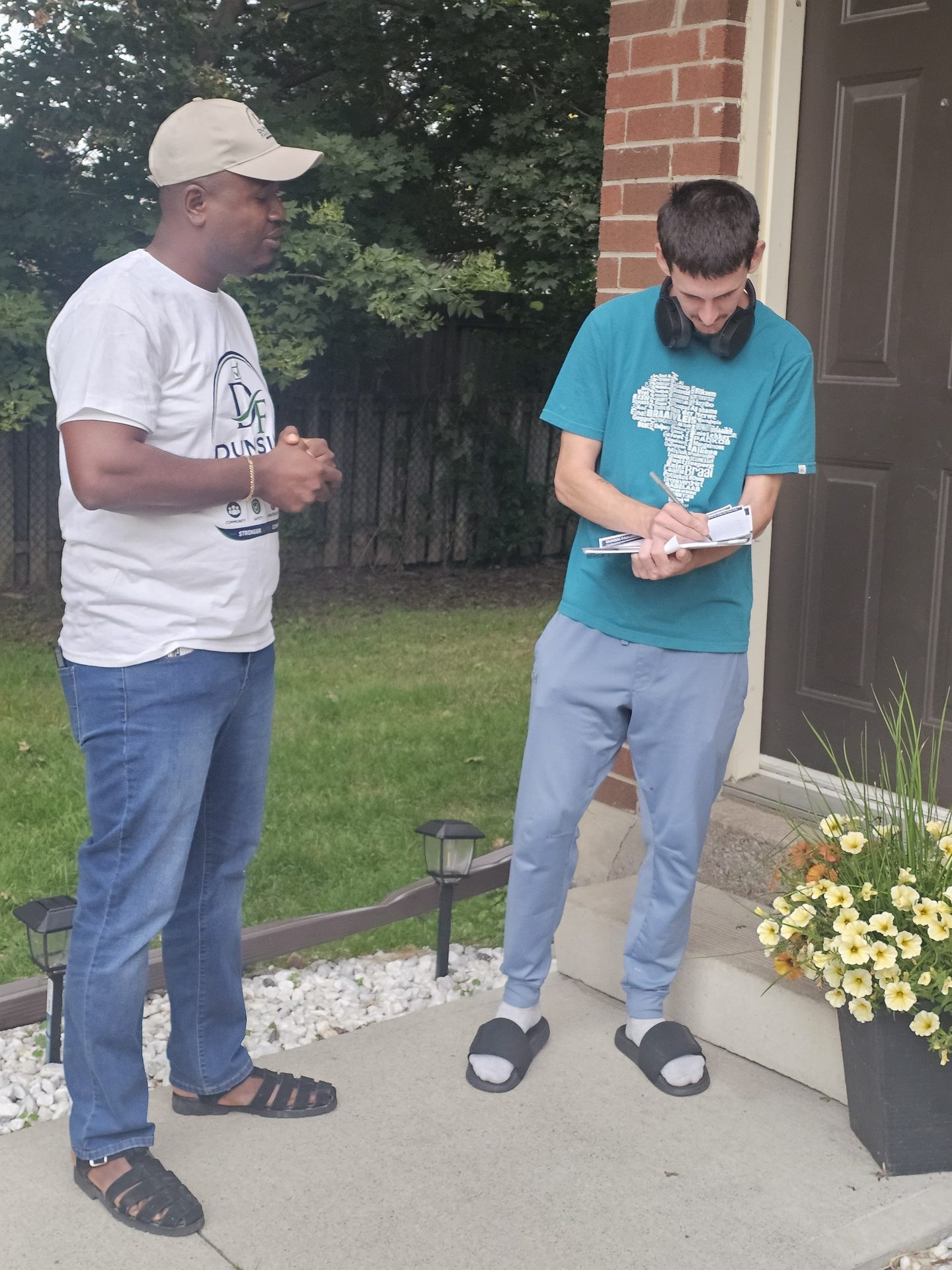 Dunsin Fakorede canvassing door-to-door with a volunteer in Ward 5